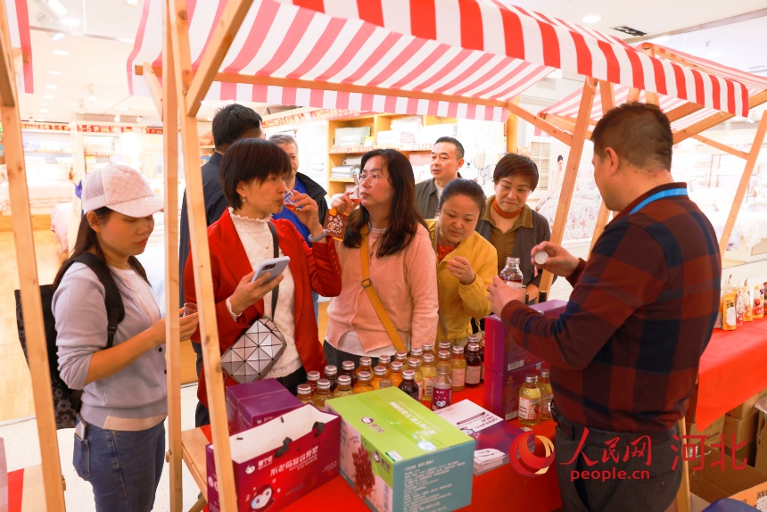 青龙满族自治县特色产业粤港澳大湾区招商对接会嘉宾参观华润超市青龙特色产品展示区。人民网 左原铭摄